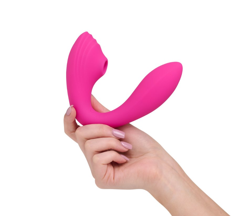 So Divine Pearl Vibe 2-in-1 in Pink held in hand – compact, curved G-spot vibrator with soft suction head for clitoral stimulation.