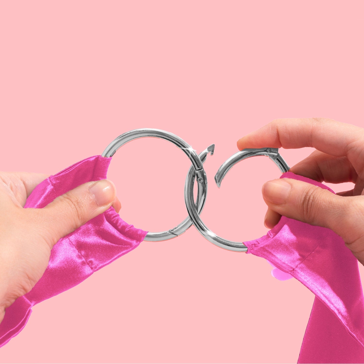 Close-up of pink So Divine silk restraints with clip-on cuffs – smooth satin finish and easy-attach clips for safe, sensual bondage.